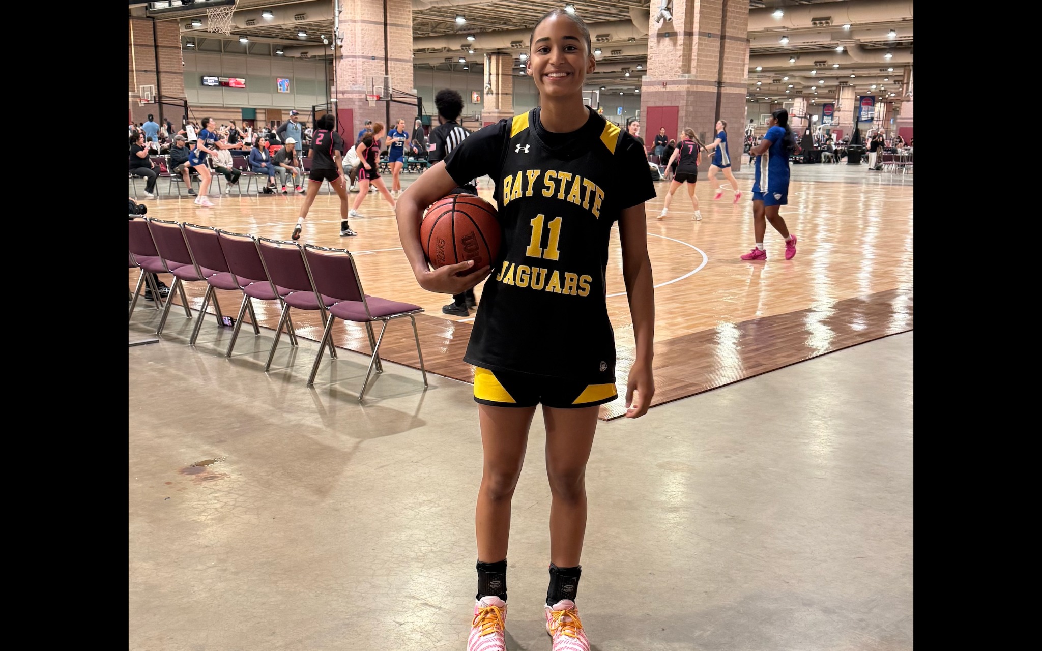 Natalia Duartes in her #11 Bay State Jaguars uniform holding a basketball